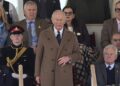 King Charles III standing as members of the King's Troop, Royal Horse Artillery perform a Royal salute in the Castle arena.