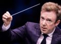 Conductor Daniel Harding raises his baton