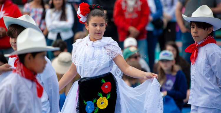 children performing a dance in traditional Mexican outfits