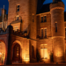 The castle is lit by orange lighting, it is dark outside.