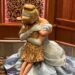 An individual dressed in a Cinderella costume is embracing another person, their faces obscured by the angle of the image. Both