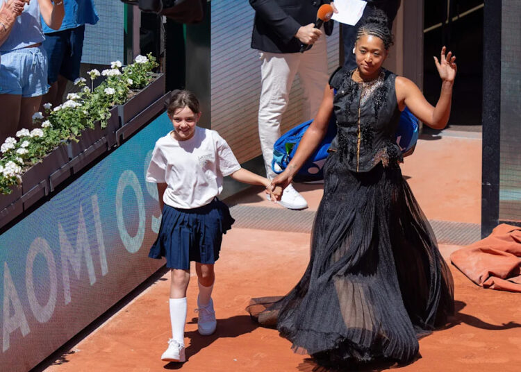 Naomi Osaka of Japan enters the court wearing a dress designed by Kevin Germanier for her match against Laura Siegemund of Germany on day three at Stade Roland Garros.