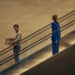 Sacha Baron Cohen as Damien Sachs and Rosamund Pike as Alex Fox