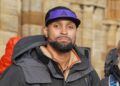 Ashley Banjo smiles at the camera wearing a hat