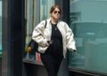 Person walking on a city street, dressed casually.