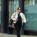 Person walking on a city street, dressed casually.