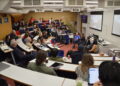Group of academics and students listening to a panel