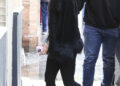 Rosalia in Seville wearing a jacket with a faux-fur trim, black capri pants, and white high-vamp ballet flats