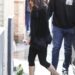 Rosalia in Seville wearing a jacket with a faux-fur trim, black capri pants, and white high-vamp ballet flats