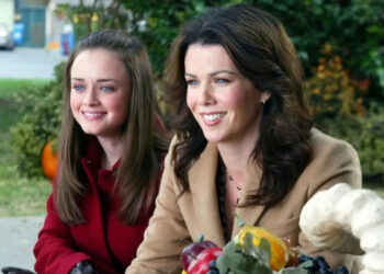 Rory and Lorelai smiling and sitting outside on Gilmore Girls