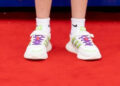 A pair of white trainers on a dazzling red carpet