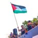 FC Barcelona player Lamine Yamal holds a Palestinian flag as he celebrates with his team atop a bus after winning the Spanish La Liga title in Barcelona.