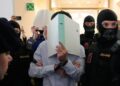 FILE - The defendants hide their faces behind file folders on their way to the courtroom in the District Court in Wiener Neustadt, Austria, where two terror suspects will stand trial Tuesday, one for plotting to carry out an attack on one of superstar singer Taylor Swift's concerts in Vienna in August 2024 and pledging allegiance to the Islamic State group, Tuesday, April 28, 2026. (AP Photo/Matthias Schrader, File)