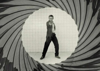 Bond aiming a gun at the camera with the barrel look around him in Casino Royale