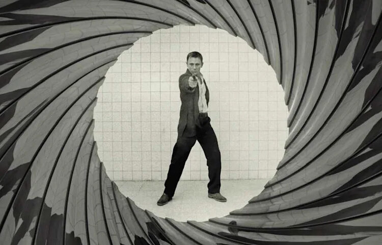Bond aiming a gun at the camera with the barrel look around him in Casino Royale
