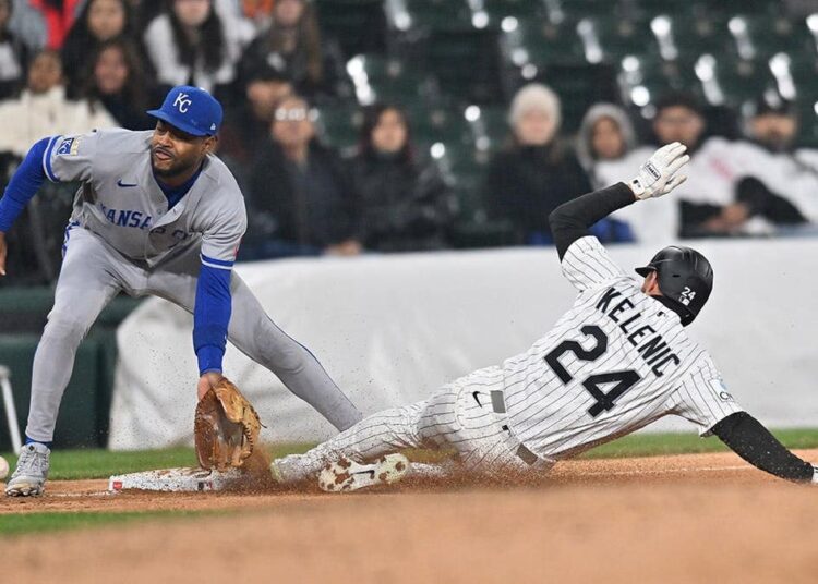 Chicago White Sox right fielder Jarred Kelenic sliding safely into third base during a baseball game.