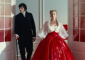 a scene featuring a man and a woman in formal attire standing at doorways