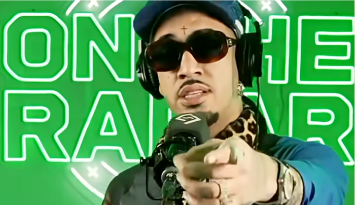Artist Fenix Flexin in front of a microphone and pointing at the camera