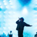 Jay-z on stage with bright blue lights in the background, musicians playing instruments on the side. This was at Roots Picnic 2026