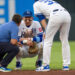 Royals shortstop Bobby Witt Jr., center, talks to manager Matt Quatraro, right, after injuring himself while fielding a ground ball during the fourth inning of a game against the St. Louis Cardinals at Kauffman Stadium in Kansas City on Thursday, June 18, 2026.