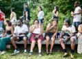 people sitting on a bench eating, drinking and laughing