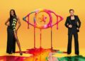 AJ Odudu and Will Best standing in front of a yellow background with the Celebrity Big Brother logo