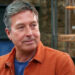 John Torode pictured on series 19 of Masterchef, wearing an orange shirt