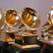 Close-up of multiple Grammy Award trophies, featuring gold gramophones on black bases, arranged in rows.