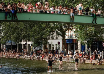 people jump into a Paris canal to cool off
