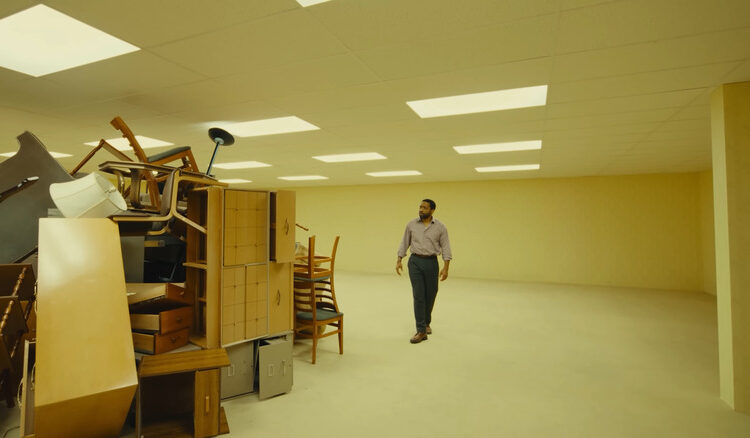 Clark looking at a mess of furniture in Backrooms