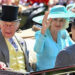 A picture of Queen Camilla, wearing a light blue outfit, and King Charles, who is wearing a yellow waistcoat and grey jacket, arriving by carriage. The back of Prince Saud bin Khalid bin Abdullah bin Abdulrahman Al Saud is also pictured.
