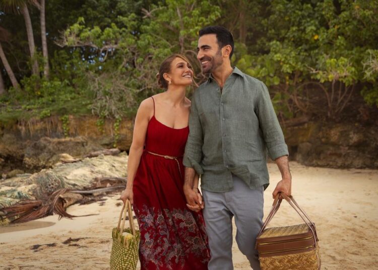 Jennifer Lopez and Brett Goldstein smiling together on a beach in