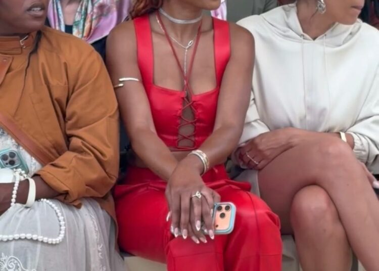 People seated in a fashion show front row, dressed stylishly.