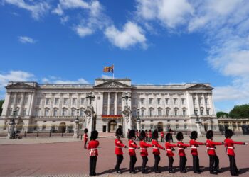 Soldiers march near the entrance to a palace.