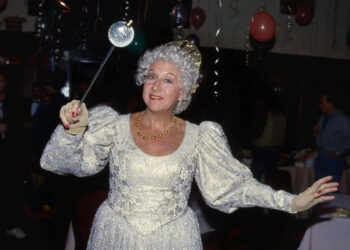 Jean Stapleton in a white dress with a wand on break during the filming of tv special 'Cinderella'.