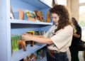 Palomino Books & Music co-owner Paloma Lopez shelves books inside her store during its Kendall-Whittier Third Thursday pop-up on June 18, 2026.