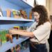 Palomino Books & Music co-owner Paloma Lopez shelves books inside her store during its Kendall-Whittier Third Thursday pop-up on June 18, 2026.