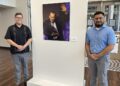 Dr. Eric Castillo, Alamo Colleges Associate Vice Chancellor for Arts, Culture and Community Impact stands with Domingo J. Figueroa, M.Ed., Program Manager of Arts, Culture, & Community Impact for the ACD. Between them is an enlarged photograph of Flaco Jimenez receiving the Grammy Lifetime Achievement Award in 2015.