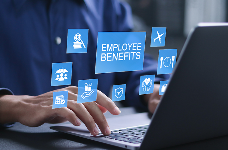 A employee sitting at a desk using a laptop with a graphic over the top saying "Employee Benifits".