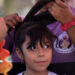 Luna Rodriguez, 7, waits to get colored hair extensions by...