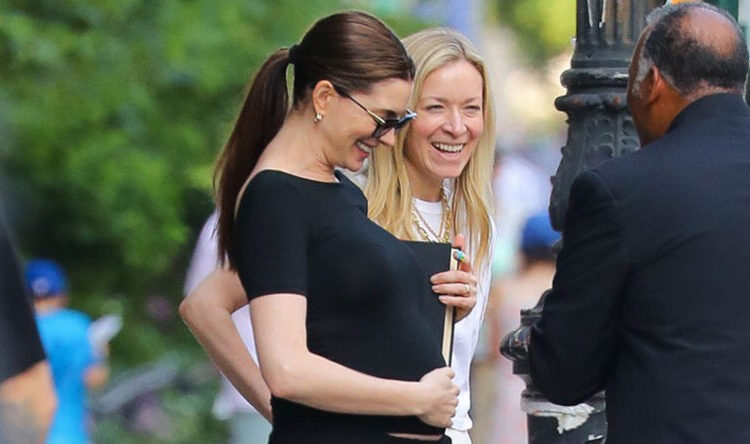 Anne Hathaway cradling baby bump june 2026