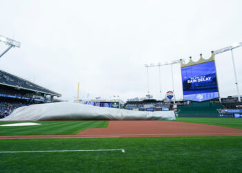 KANSAS CITY, MO - APRIL 15: Members of the grounds crew adjust the tarp during a rain delay before the Kansas City Royals take on the Atlanta Braves at Kauffman Stadium on April 15, 2023 in Kansas City, Missouri. All players are wearing the number 42 in honor of Jackie Robinson Day. (Photo by Kyle Rivas/Getty Images)