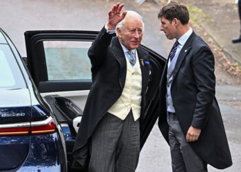 King Charles waves as he arrives to attend the wedding of Princess Anne's son, Peter Phillips and Harriet Sperling at All Saints' Church