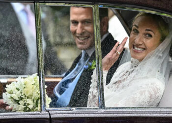 Harriet Sperling waves from a vehicle as she sits with Peter Phillips (Reuters)