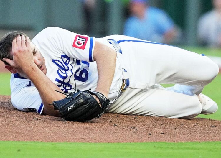 Kansas City Royals pitcher Seth Lugo dropping to the mound after being hit by a line drive.