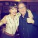 Taylor Swift wearing a tie-dye Agolde bodysuit with black jeans and opal jewelry with brown bangs and a ponytail posing in a recording studio