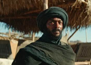 Anthony Mackie as the bandit standing in front of a grass hut in Desert Warrior
