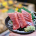 A hand holding fish tartare in Tsukiji Outer Market, Japan