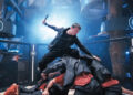 Xie Miao's Wang Wei stands atop a pile of thugs wielding a hammer in The Furious