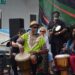 People play drums at an outdoor event.